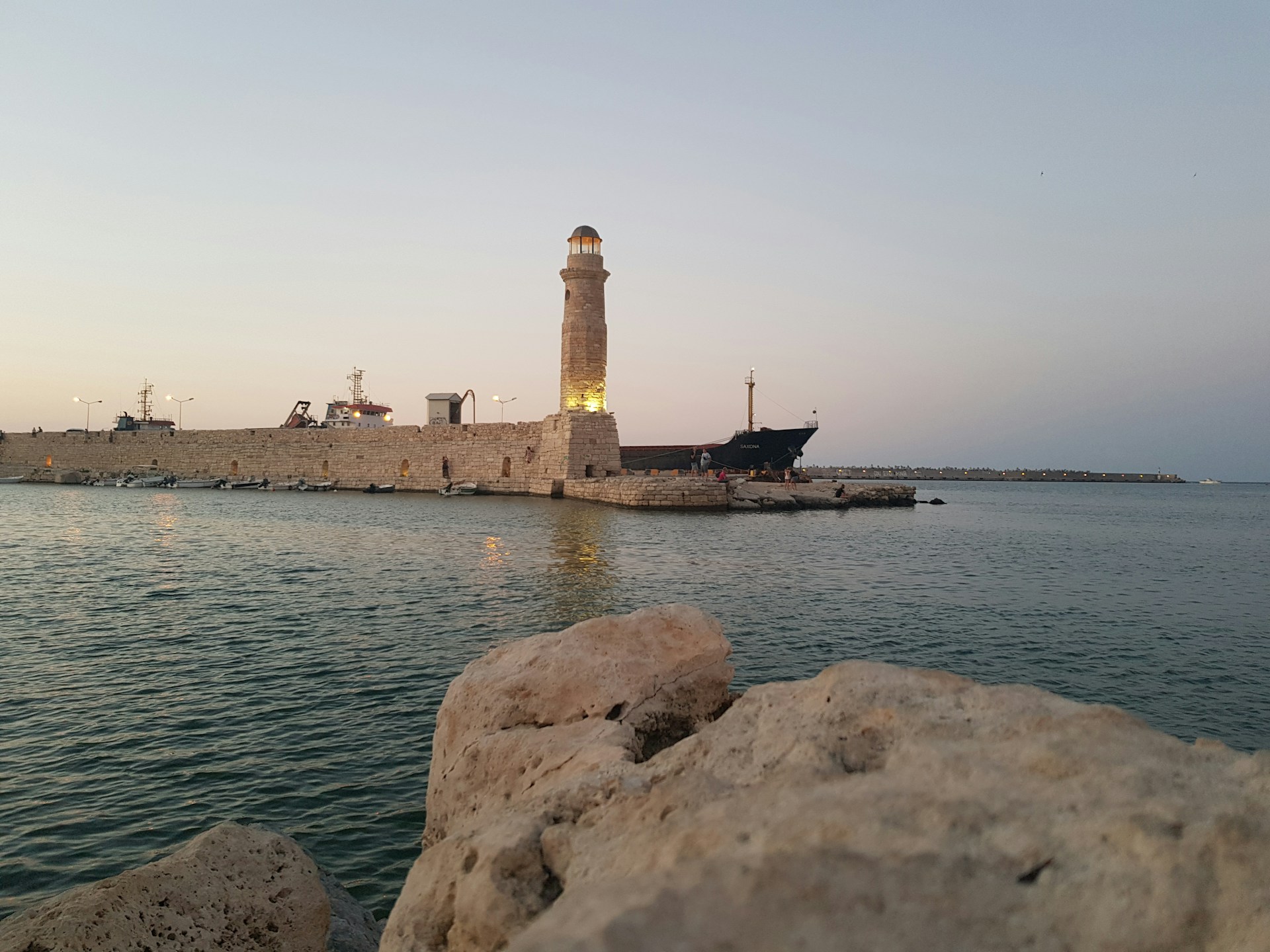 Stunning angle of the lighthouse by the Venetian Harbor in Rethymno Crete during sunset