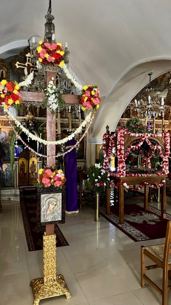Cross of Jesus Christ next to the epitafio decorated in flowers in a small church in Margarites, Rethymno Crete