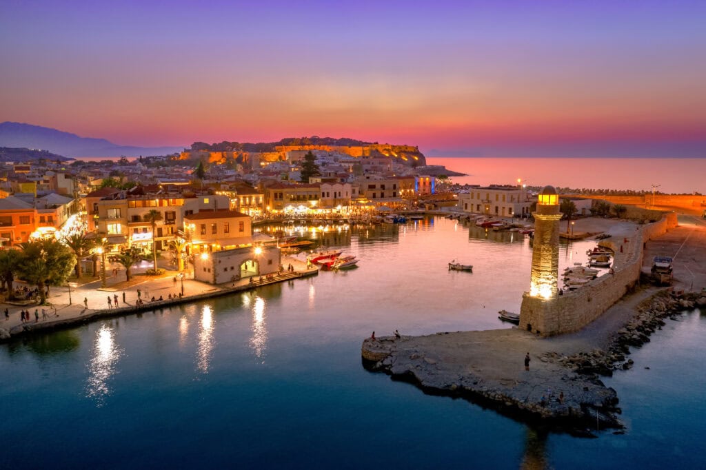 view of rethymno harbor and parts of city during pink sunset