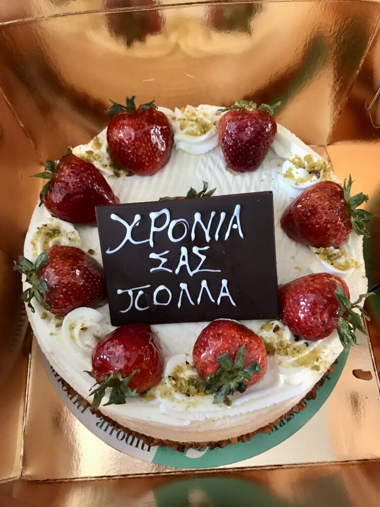 strawberry shortcake cake written "HRONIA POLLA" in Greek